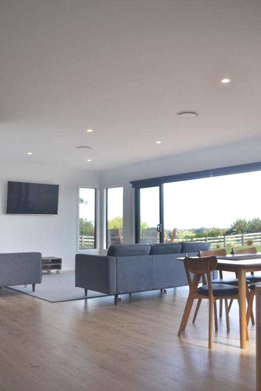 a living room with a couch and a table at Brooklyn Views - 4 Bedrooms in Feilding