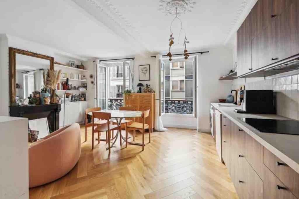une cuisine et une salle à manger avec une table et des chaises dans l'établissement Design appartement in Le Marais, à Paris