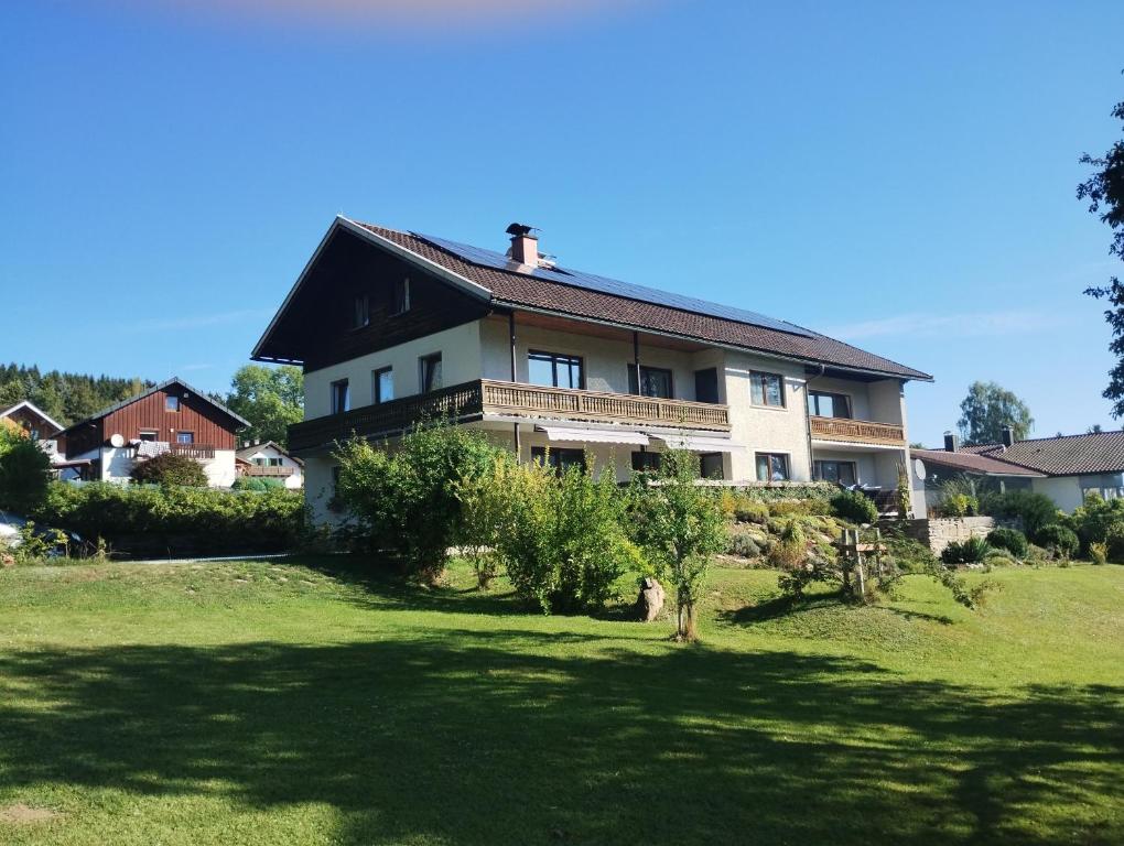 une maison sur une colline avec une cour verte dans l'établissement Wohnung Martha, à Bayerisch Eisenstein