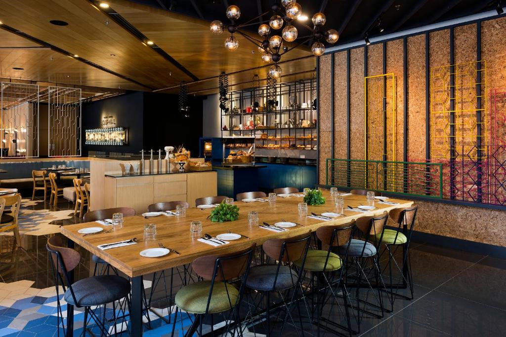 a dining room with a long table and chairs at The Kuala Lumpur Journal Hotel in Kuala Lumpur