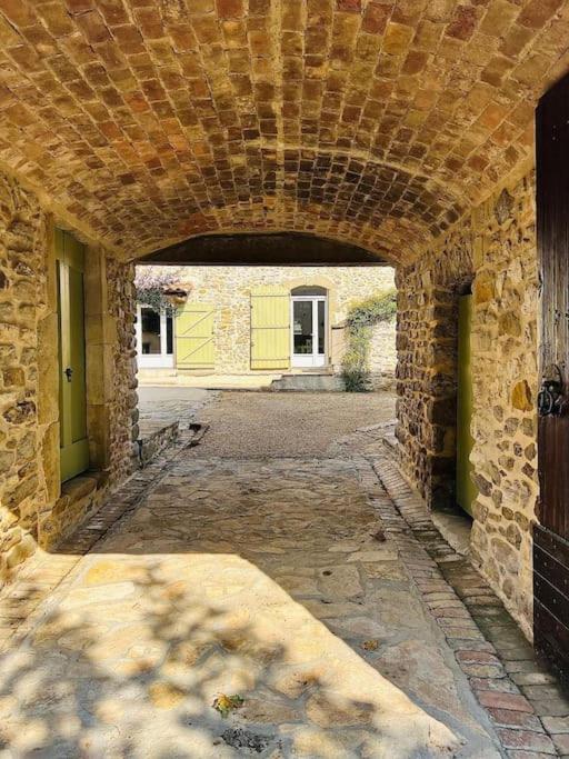 - l'entrée d'un bâtiment en pierre avec une arche dans l'établissement Le Gîte Mas de Novis Vieux Mas du XVIIIe siècle, à Saint-Hilaire-de-Brethmas