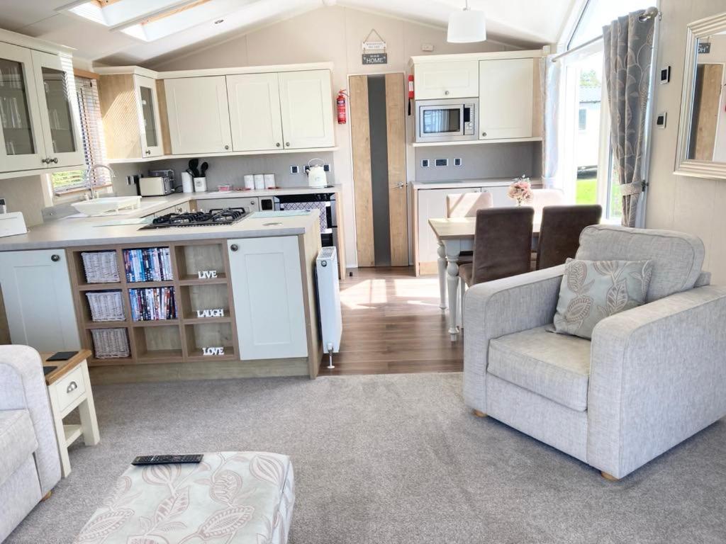 a kitchen and living room with a couch and a table at Vogue at Primrose in Reighton