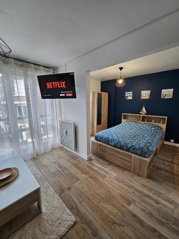 - une chambre avec un lit et une télévision murale dans l'établissement Studio Voltaire - Centre ville, à Saint-Brieuc