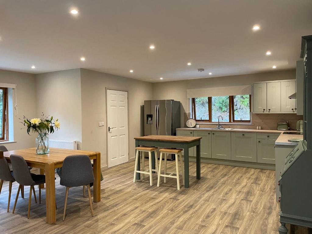a kitchen with a table and chairs and a refrigerator at Llety Cynnes in Machynlleth