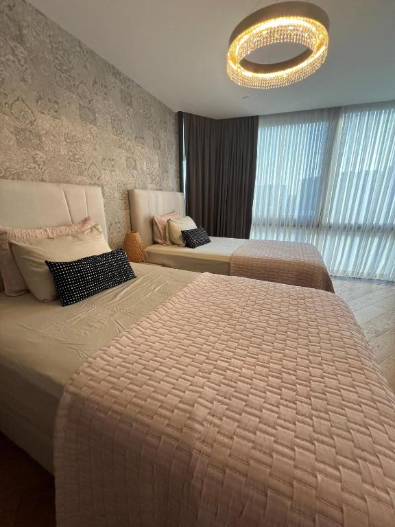 a hotel room with two beds and a chandelier at Deluxe 2BR Apartment Balcony 420 in Istanbul