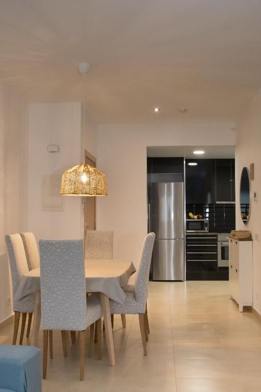 a kitchen and dining room with a table and chairs at Modern Beach Apartment - La Maca in Tamariu