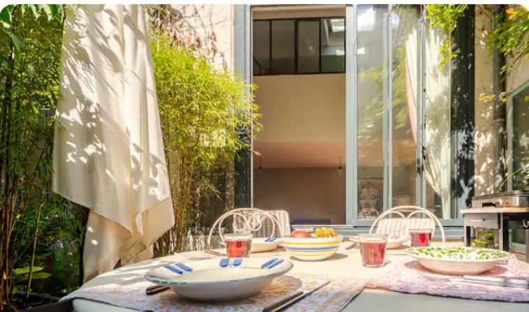 une table avec des bols et des assiettes de nourriture dans l'établissement Maisonette indépendante tout confort et son jardin, à Paris