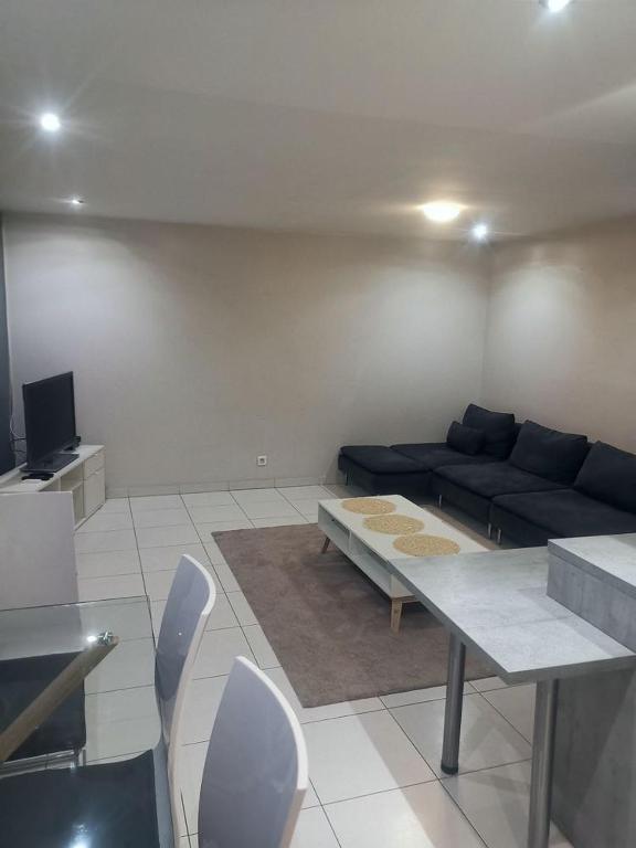 un salon avec un canapé, une table et des chaises dans l'établissement Chapeau Rouge - Appartement au cœur de la ville, à Dijon