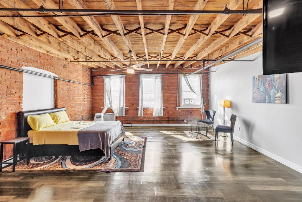 a bedroom with a bed and a brick wall at Stylish Chic Retreat at Lafayette Lofts apts in Detroit