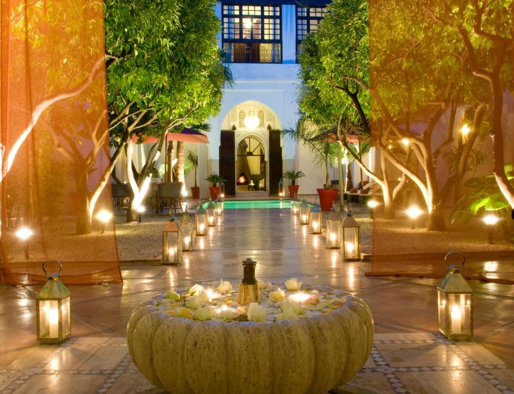 a courtyard with lights and a large bowl with candles at Riad Charaï in Marrakech