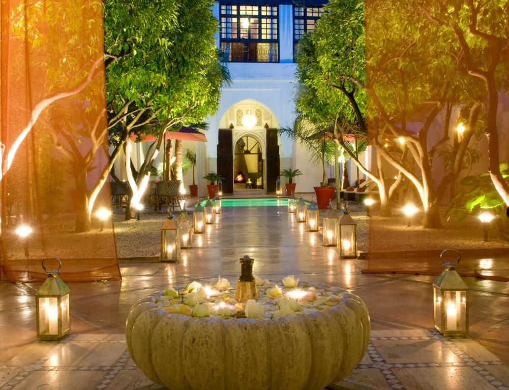 a courtyard with lights and a large bowl with candles at Riad Charaï in Marrakesh