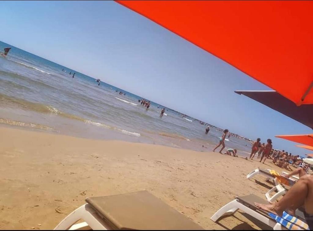 a group of people on a beach with the ocean at Villa della Concordia in Plaia Grande