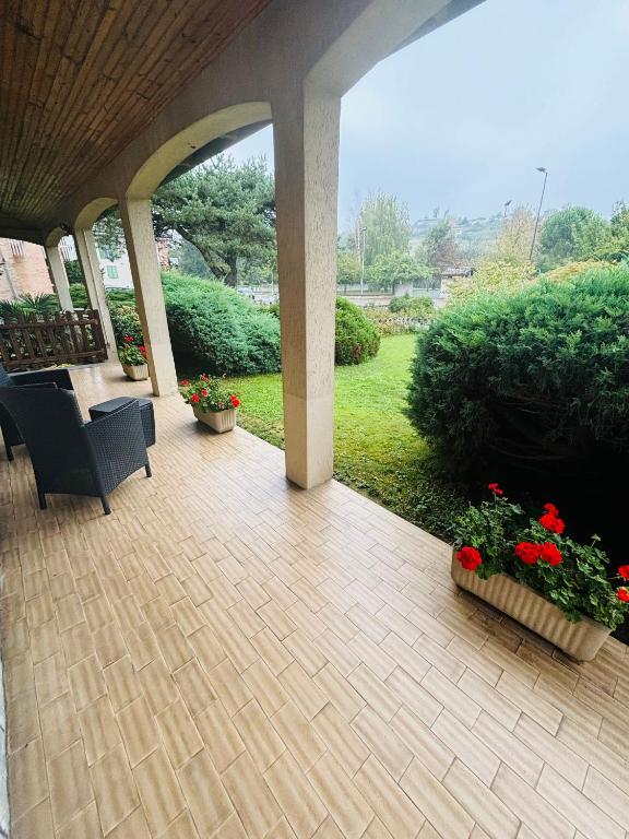 a patio with a chair and flowers in a yard at Casa tra le vigne in Mombercelli