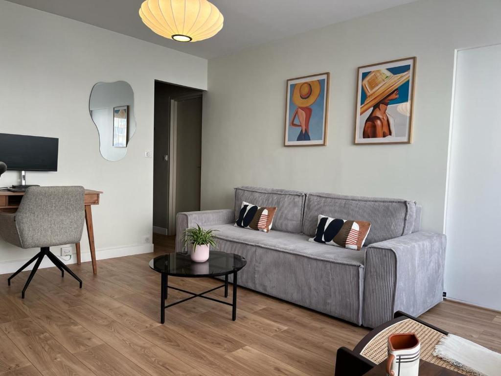 a living room with a couch and a table at Bel appartement Ouest Parisien in Boulogne-Billancourt
