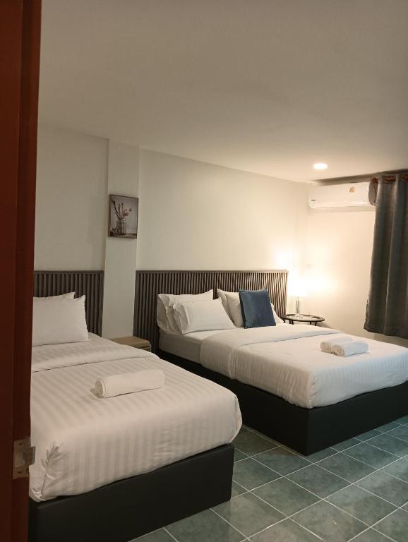 a hotel room with two beds in a room at Matinee House Hatyai in Hat Yai