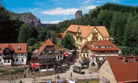 um grupo de edifícios numa cidade com árvores em Amselgrundschlösschen em Kurort Rathen