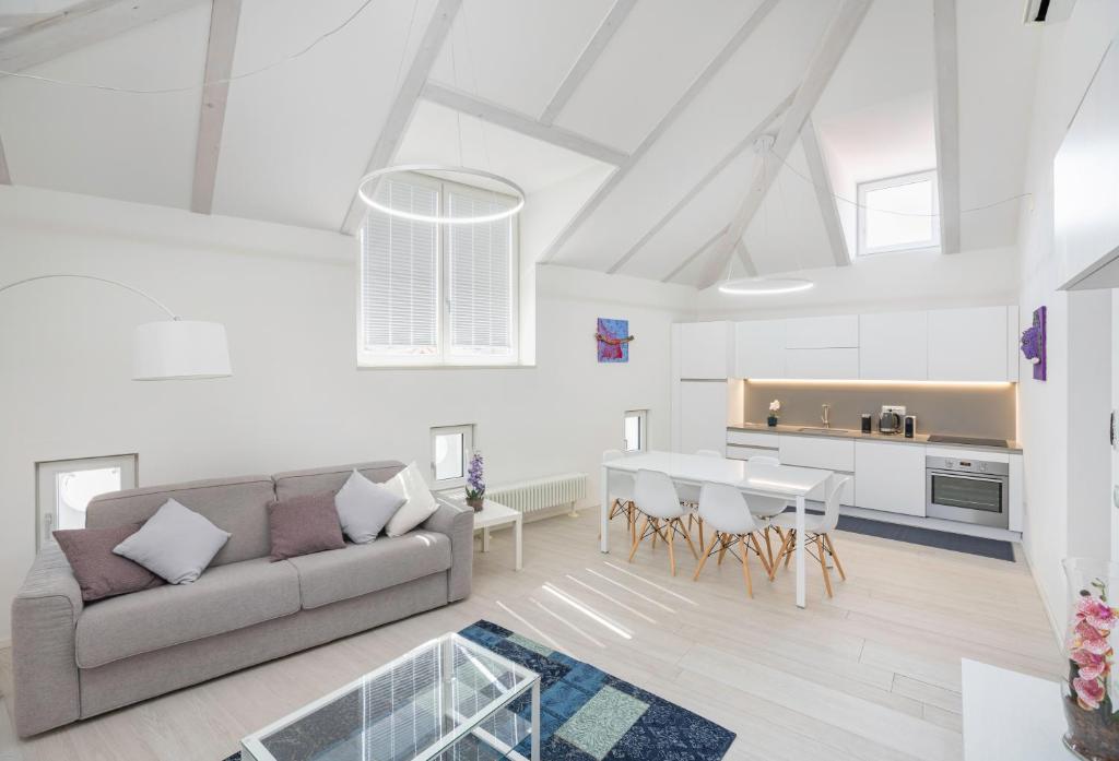 a living room and kitchen with a couch and a table at Sweethome Gries - Con Garage in Bolzano