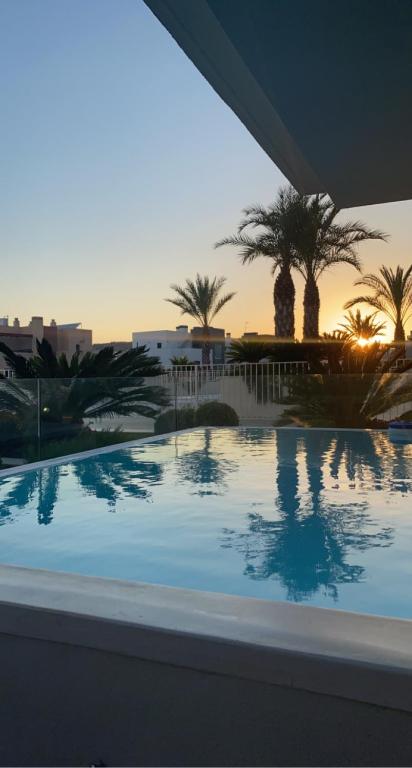 a large swimming pool with palm trees in the background at Fantastisk 4 roms med egen dipping Pool in Mijas Costa