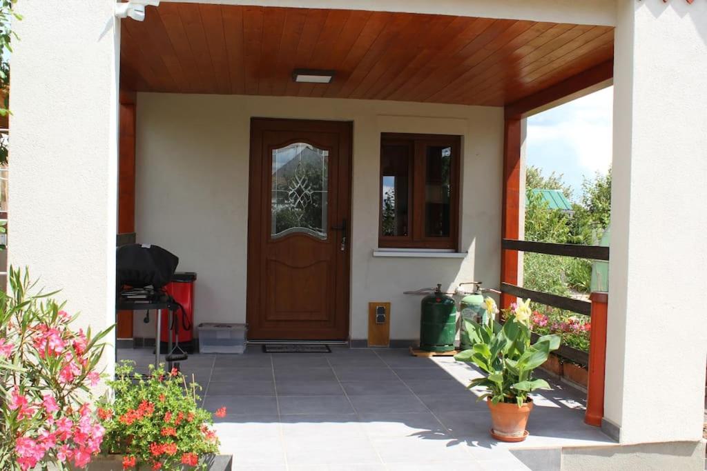 a front door of a house with flowers at Garte Hiesel la maison de jardin Piscine été 2026 in Scherwiller