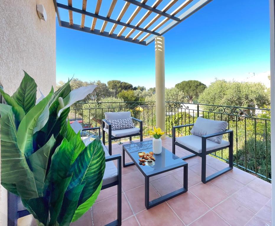 un patio avec des chaises, une table et une plante dans l'établissement Bastidon de l'Olivaie, à Bandol
