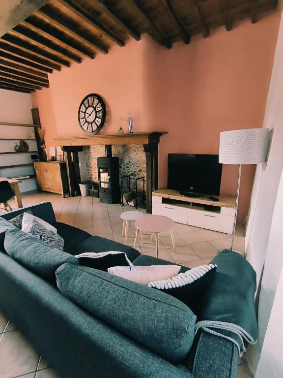 un salon avec un canapé bleu et une cheminée dans l'établissement Gite dans un village des Pyrénées, à Luc