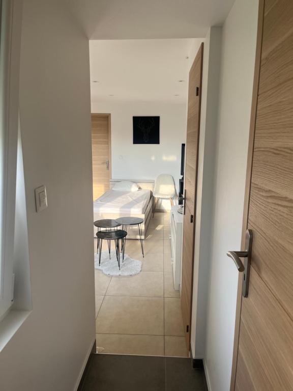 un couloir menant à une chambre avec un lit et une table dans l'établissement Le petit nouveau avec Jardin, à Pont-à-Mousson