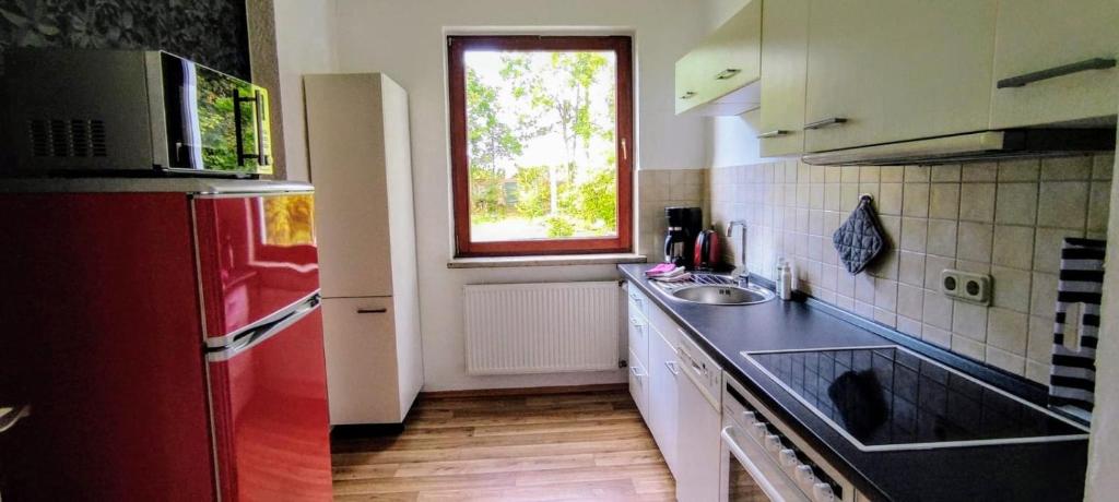 a kitchen with a red refrigerator and a sink at Ferienwohnung am Kloster in Duderstadt