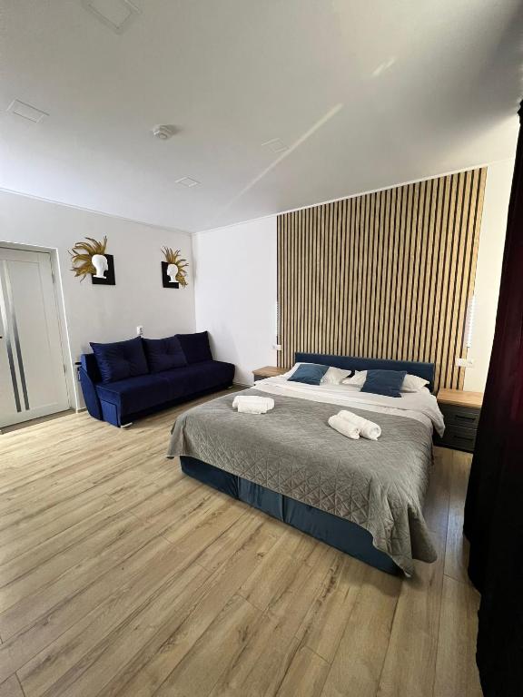 a bedroom with a bed and a blue couch at Maysa Ap in Turda