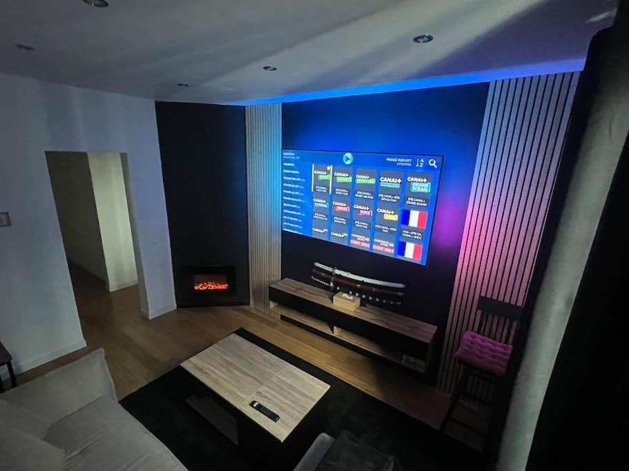 un salon avec une télévision, un canapé et une table dans l'établissement T2 Elégant, Proche de tout, à Choisy-le-Roi