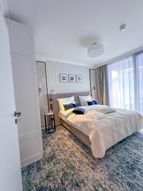 a bedroom with a large bed and a large window at Central Park Mielno Operator Team- apartament IVO in Mielno