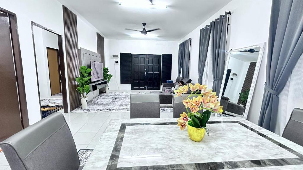 a living room with a table with flowers on it at Homestay White Aqil in Kampong Paya Pulai