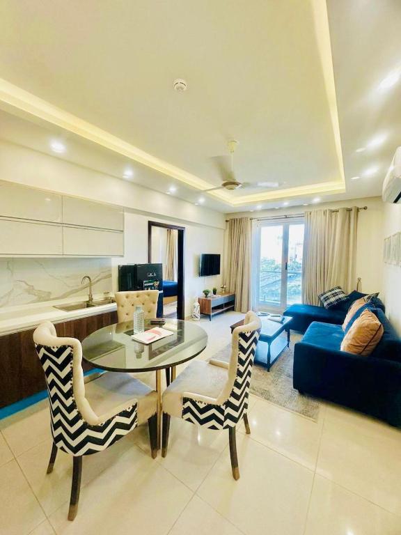 a living room with a glass table and chairs at Elysium Luxury 1Bed Apartment! Opposite to Centaurus Mall in Islamabad