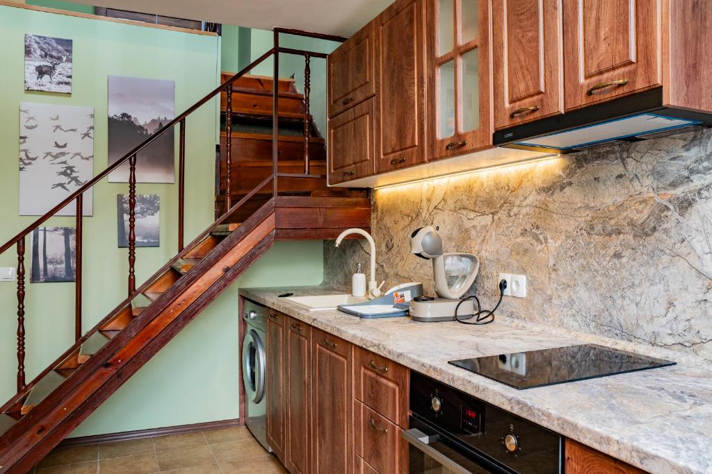 a kitchen with wooden cabinets and a staircase at Alpine Retreat Maisonette in Bansko