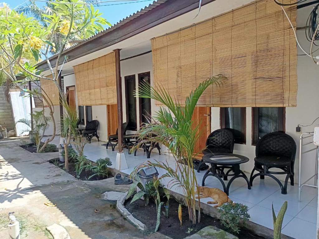 吉利特拉旺安Purba Rooms Gili Trawangan的房屋设有带椅子和桌子的庭院