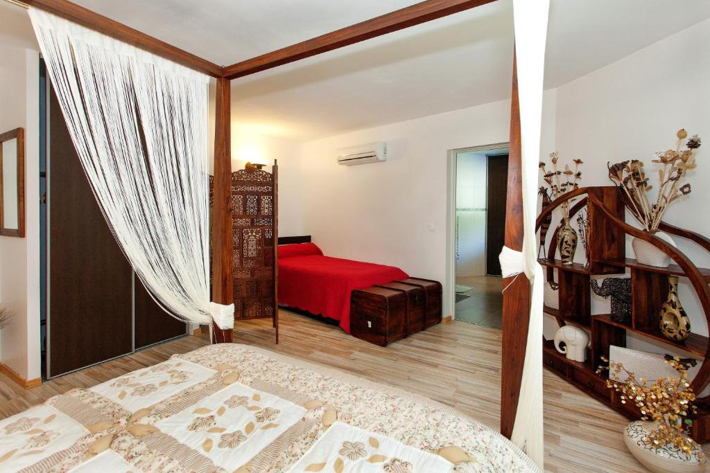 a bedroom with a bed with a red blanket at Appartement SAB in Issel