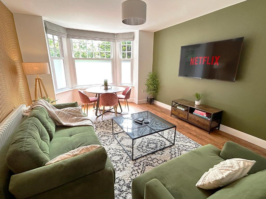a living room with a green couch and a table at 1 Bed & 1 Sofa Bed Alpine Style Ground Floor Apartment in Yeovil