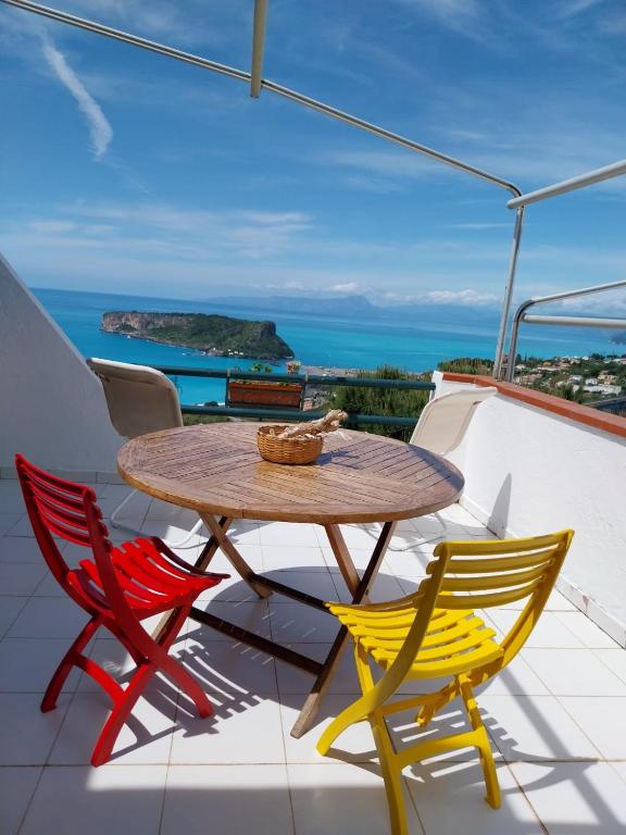 a table and chairs on a balcony with a view of the ocean at Casa Re di Picche in San Nicola Arcella