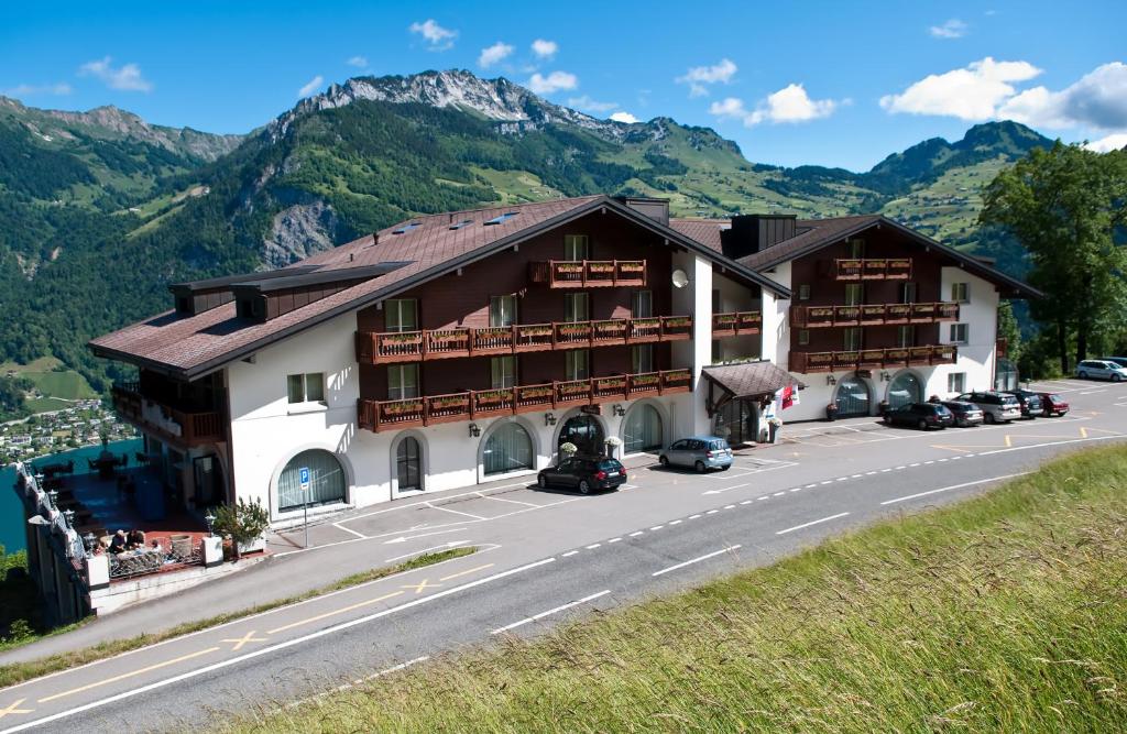 un edificio al lado de una carretera con montañas en Seminar- & Erlebnishotel RömerTurm, en Filzbach