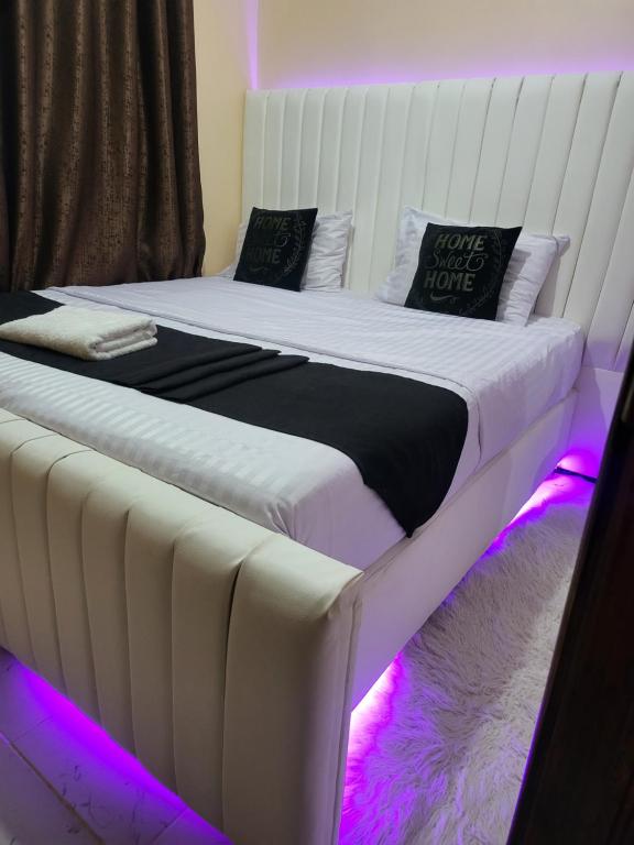 a bedroom with two beds with purple lights at G&G Homes Pioneer 1 bedroom in Eldoret
