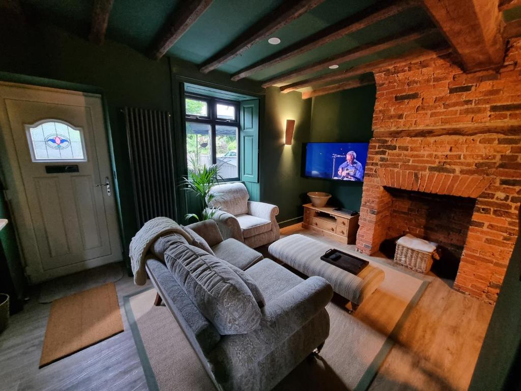 Una televisión o centro de entretenimiento en Rose Cottage Oulton Leeds