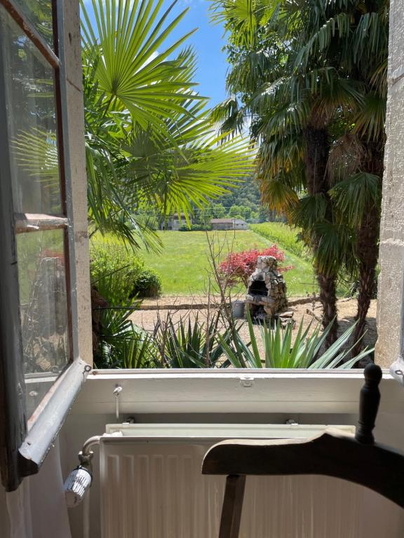 an open window with a view of a garden at Maison de Famille Les Tourelles in Tour-de-Faure