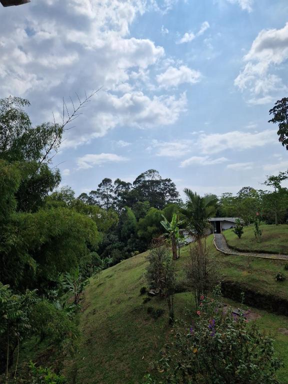 a grassy hill with a house in the background at Bhutan Filandia in Filandia