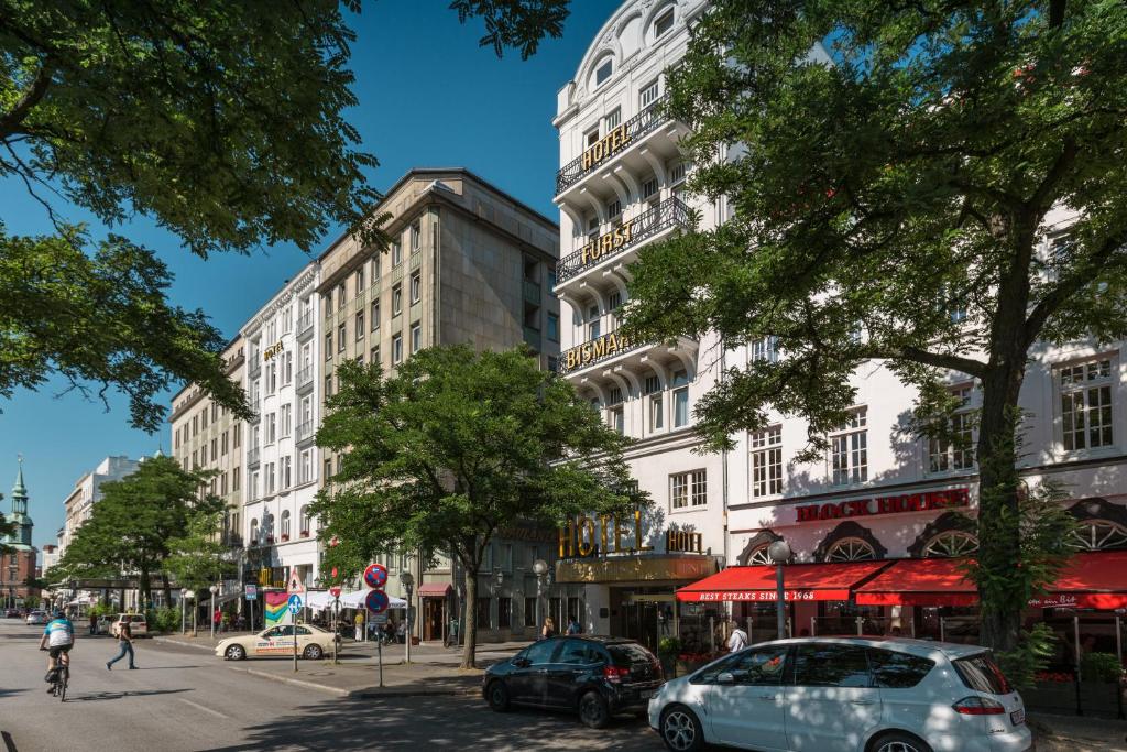 un edificio blanco alto con coches aparcados en una calle en Hotel Fürst Bismarck, en Hamburgo