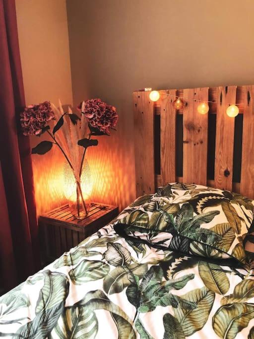 - une chambre dotée d'un lit avec une couverture et des fleurs dans l'établissement Superbe appartement T3 dans l'hyper centre, à Blois