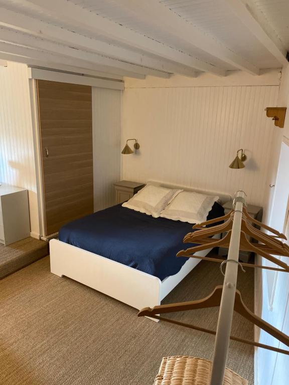 a bedroom with a large bed with a blue blanket at Cottage en vignoble in Leynes