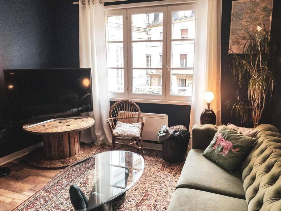 een woonkamer met een bank, een tafel en een raam bij Superbe appartement T3 dans l'hyper centre in Blois