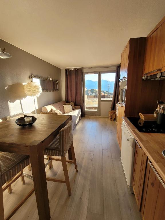 une cuisine et un salon avec une table et un canapé dans l'établissement Alpe d'Huez 21, à Huez