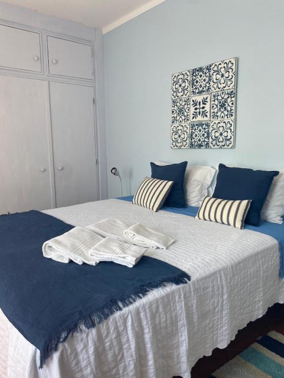 Un dormitorio con una cama grande con sábanas azules y blancas. en Casa do Portão Azul - Espadarte, en Atouguia da Baleia