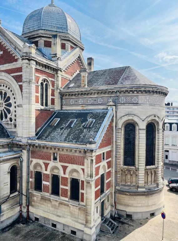 un ancien bâtiment en briques avec un dôme en haut dans l'établissement Lille Parvis St Michel, à Lille