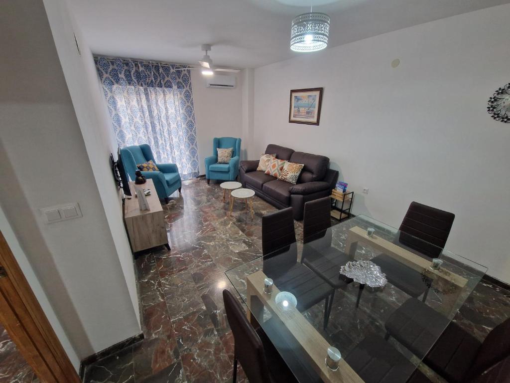 een woonkamer met een bank, een tafel en stoelen bij Marfil 6 in Salobreña